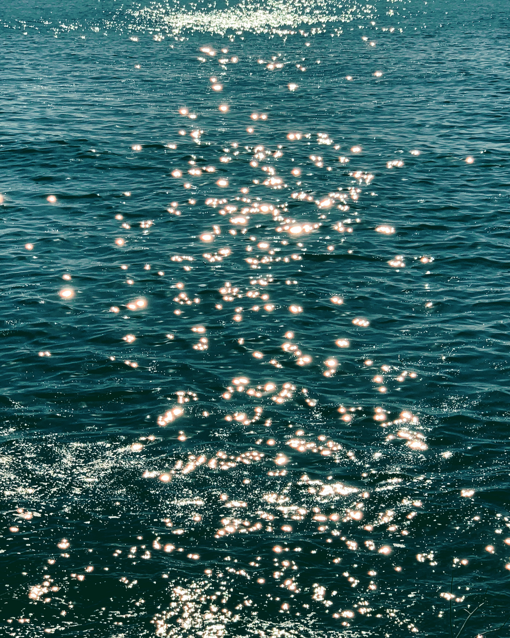 Ocean photograph print titled Pure Magic, showing sunlight sparkling across deep teal water with rippling waves.